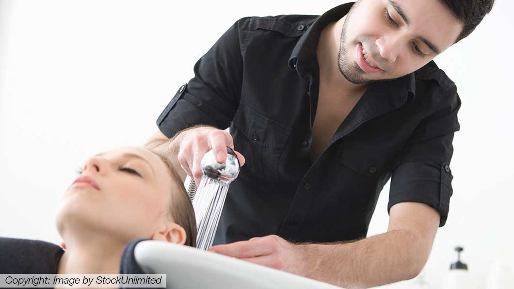 Friseur wäscht die Haare einer Kundin