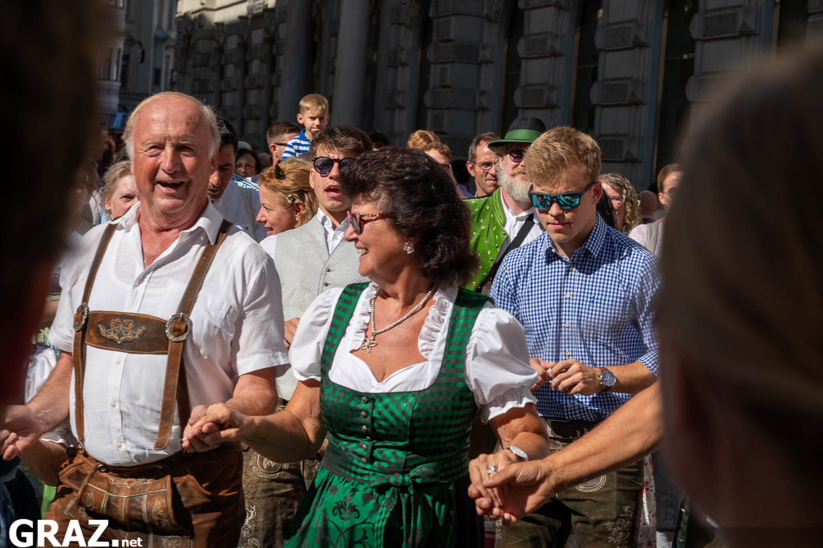 Tanzende Gruppe mit Tracht und Alltagskleidung