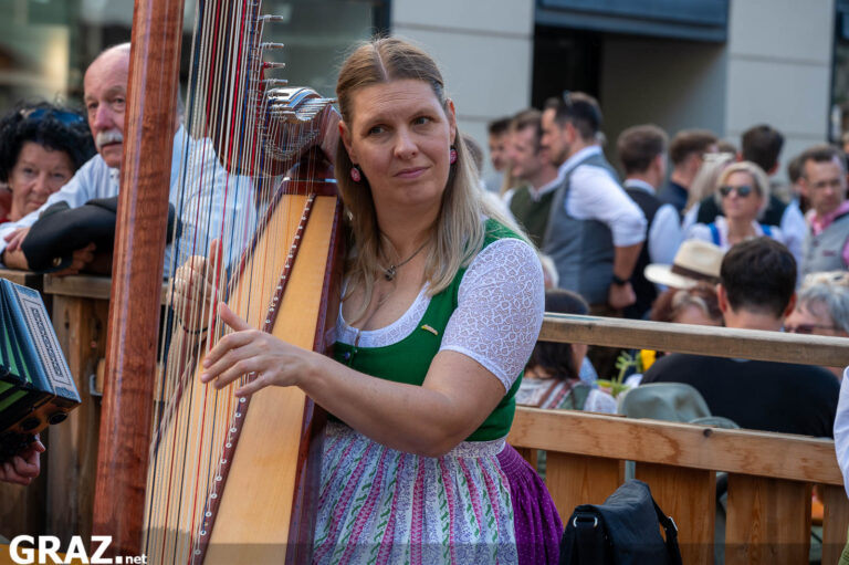 Harfenspielerin vor einem Volkstanzpaar