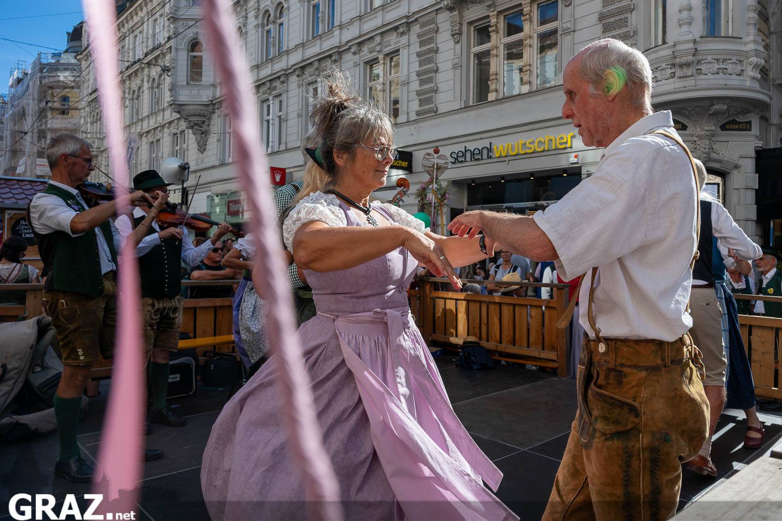 Paar in Tracht tanzt auf einer kleinen Bühne