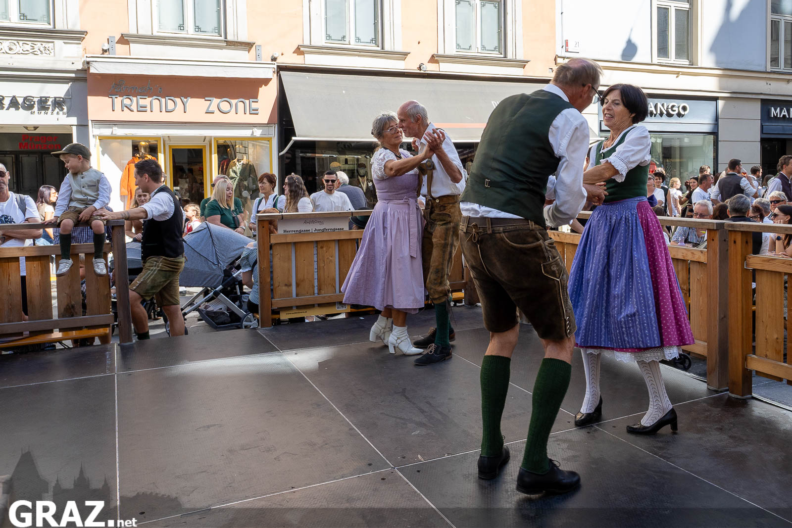 Volkstanz in Dirndl und Lederhose vor Publikum