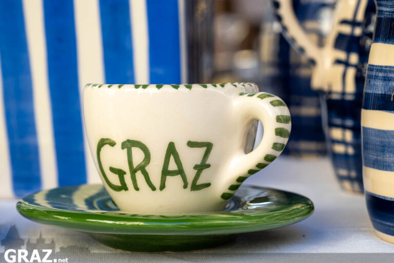 Keramiktasse mit der Aufschrift Graz an einem Stand