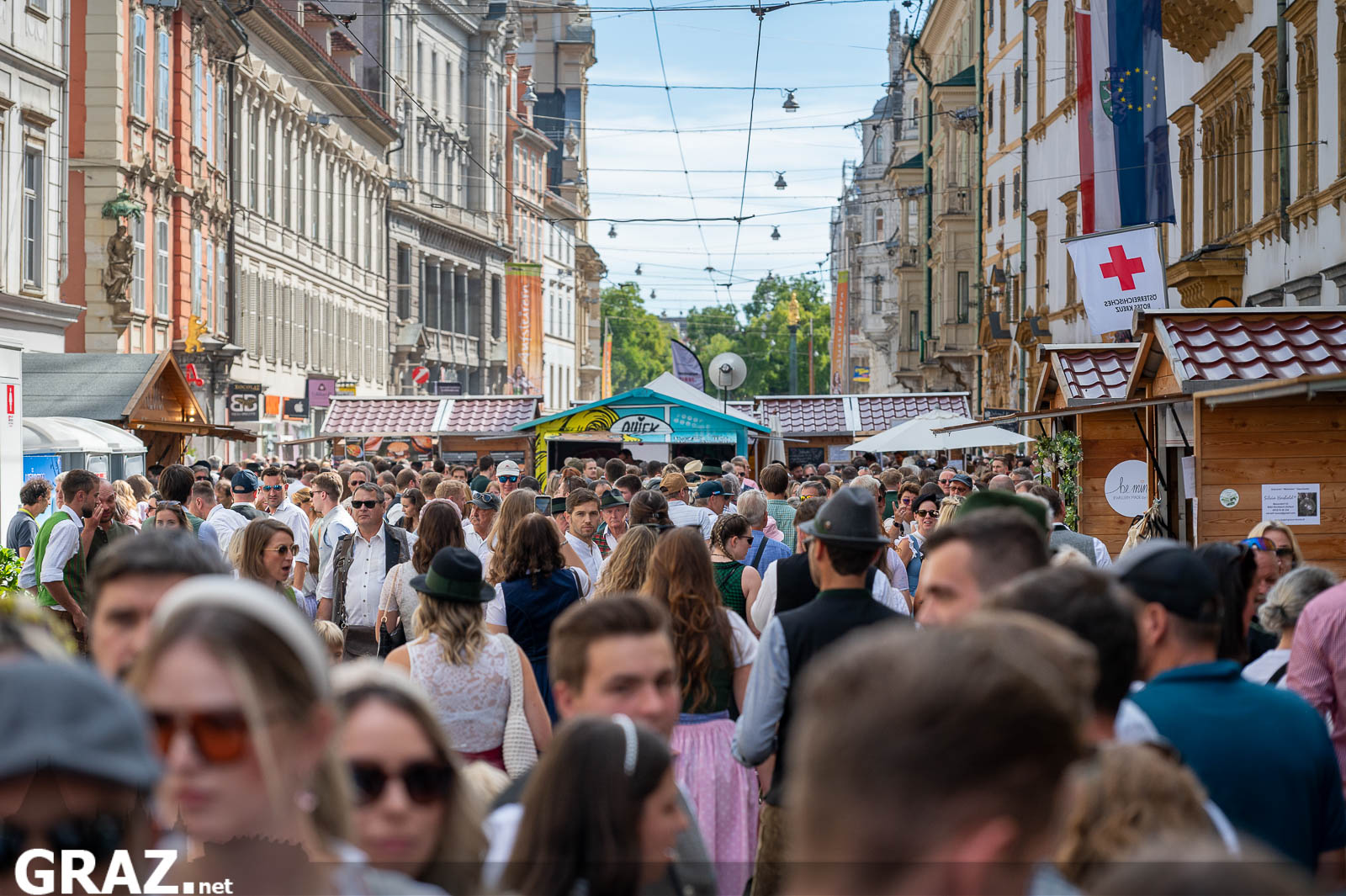 Dicht besuchte Gasse mit Trachten und Marktständen