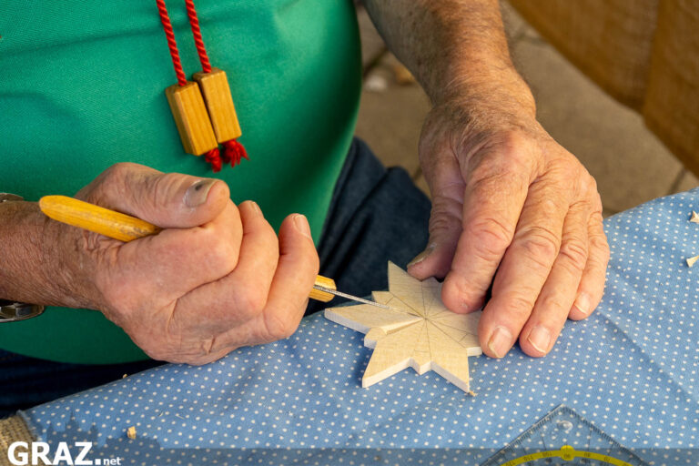 Handwerker schnitzt einen kleinen Holzstern