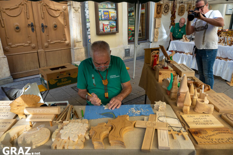 Holzschnitzer mit handgefertigten Waren an seinem Stand