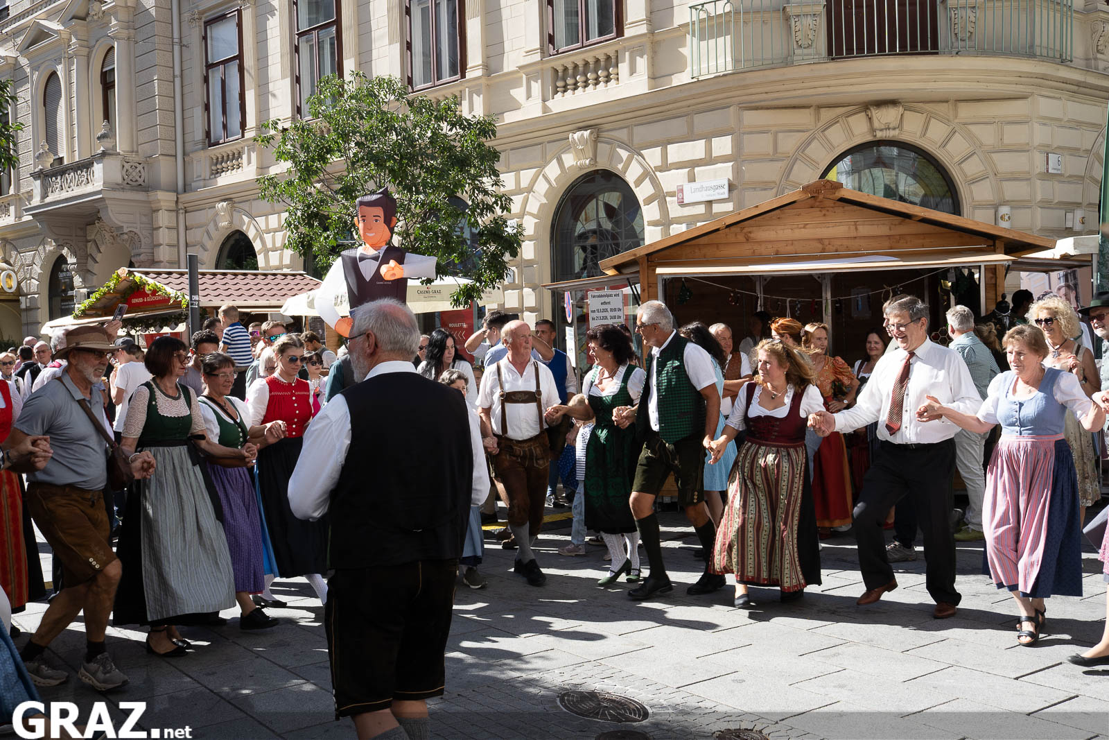 Paare beim gemeinsamen Volkstanz zwischen den Festständen