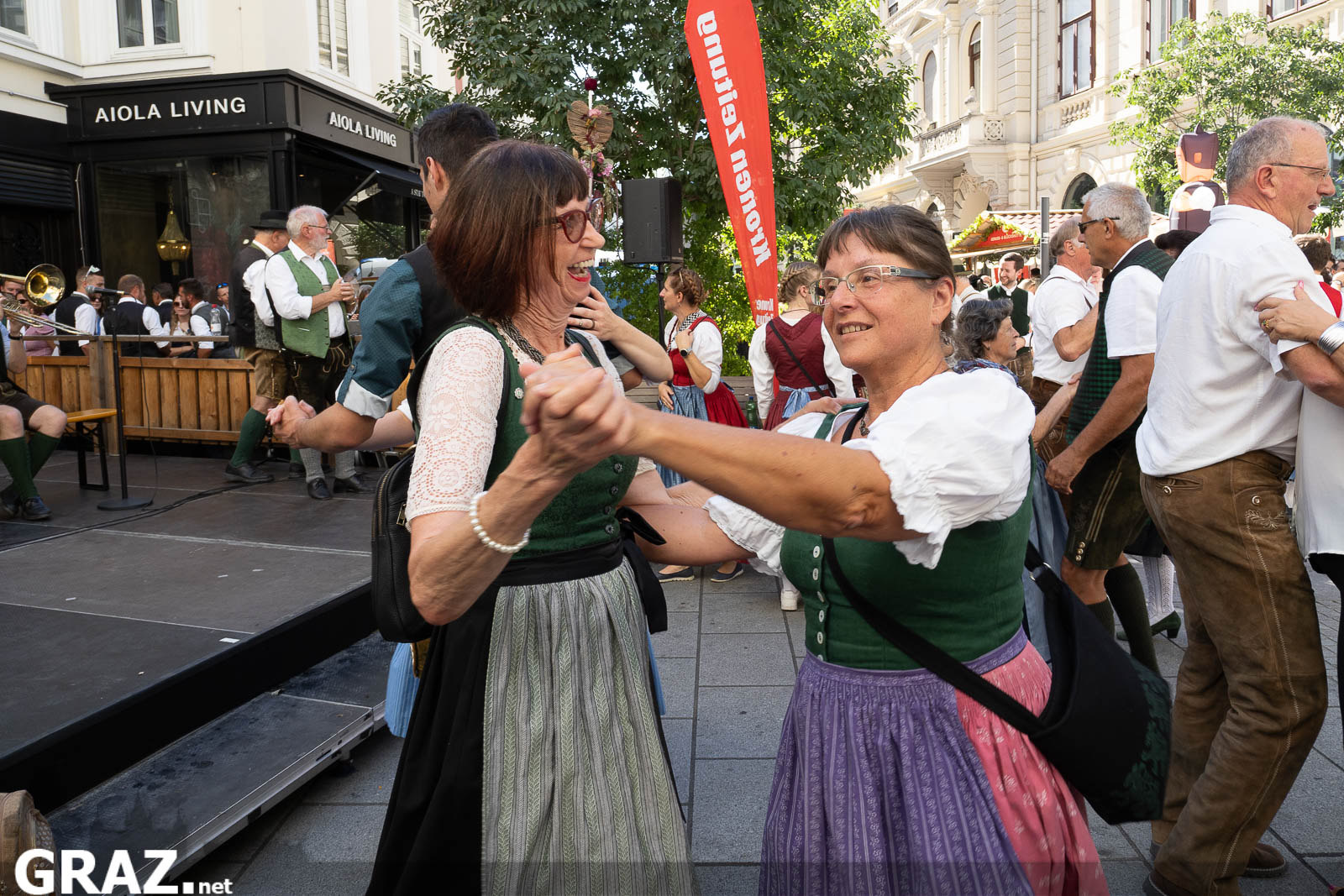Zwei Frauen tanzen lachend auf der Straße