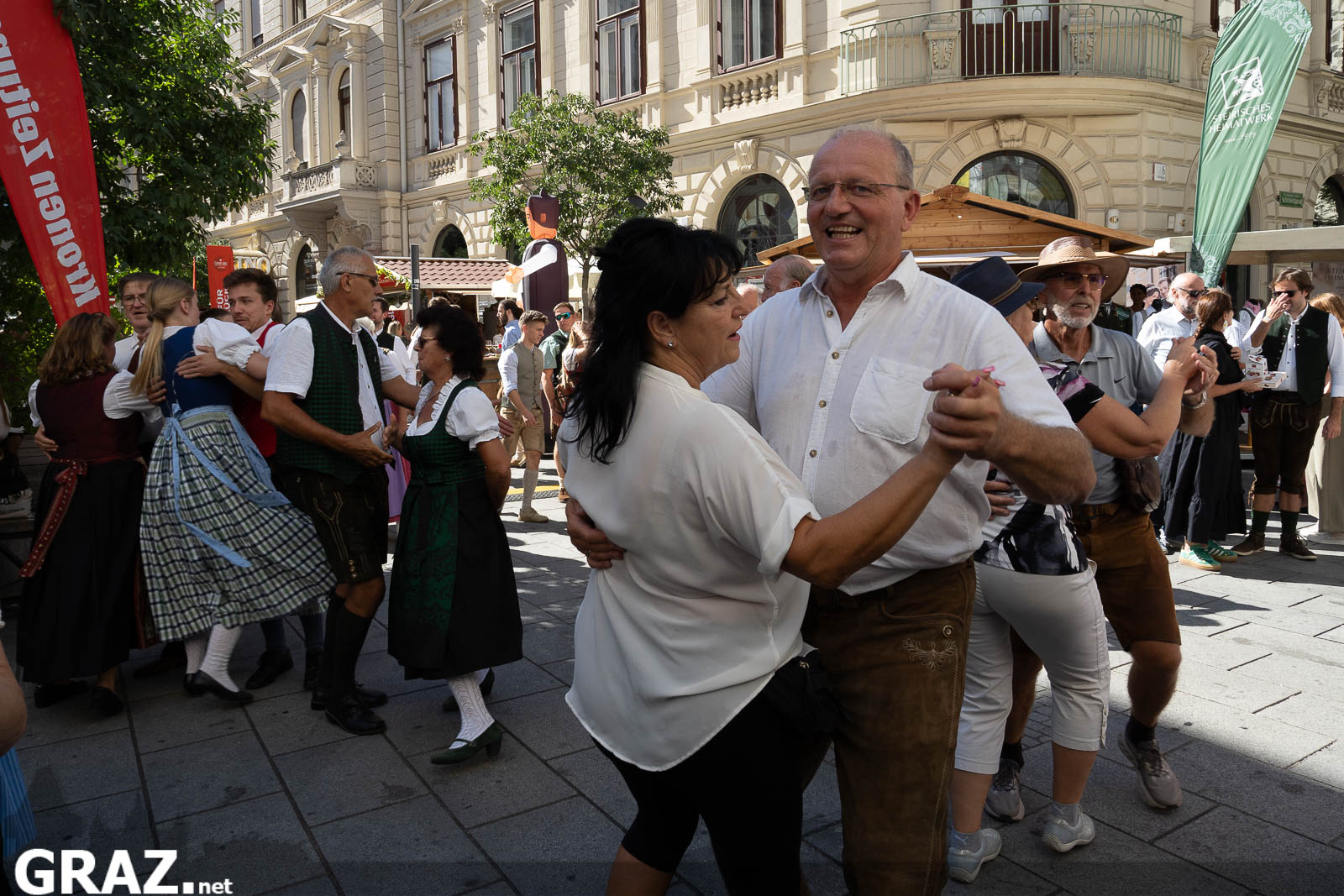 Tanzpaar in Weiß und Tracht mitten im Festgeschehen