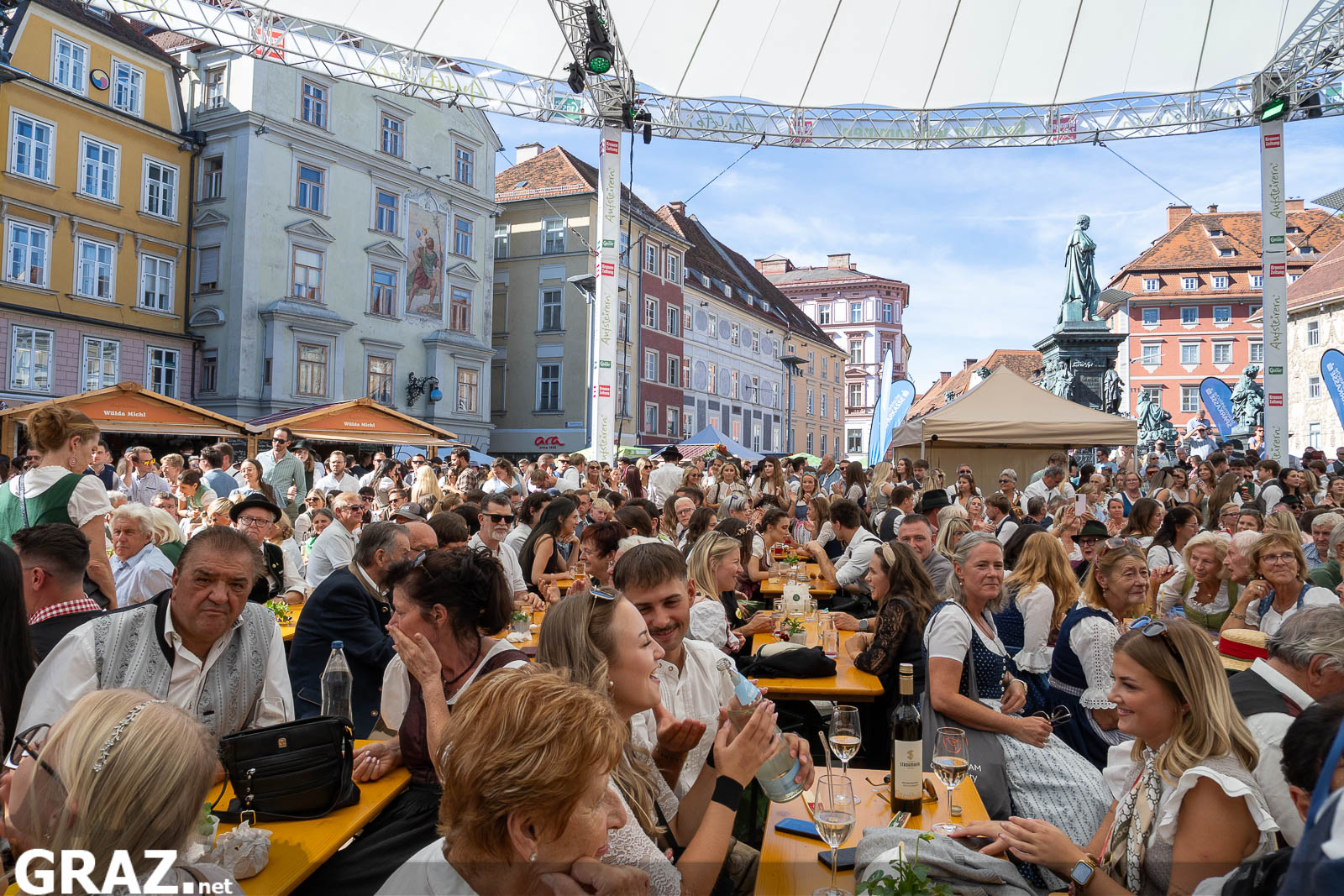 Festgäste an Tischen auf dem Hauptplatz vor dem Erzherzog-Johann-Brunnen