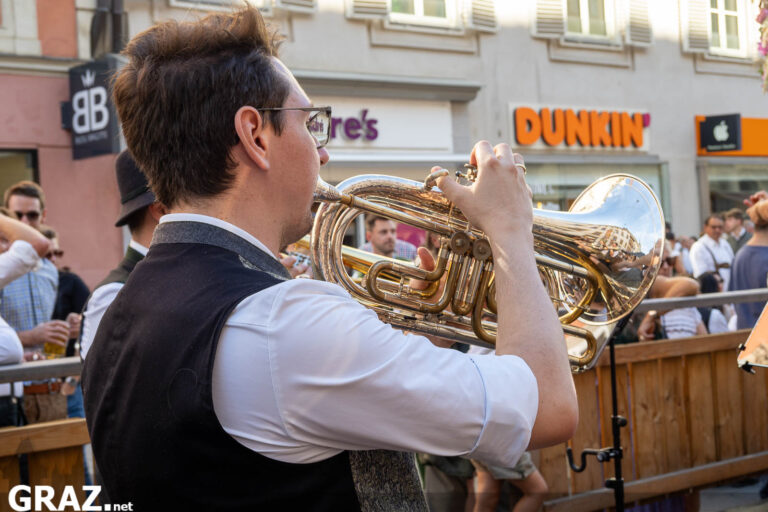 Trompeter spielt vor einer Gruppe tanzender Menschen