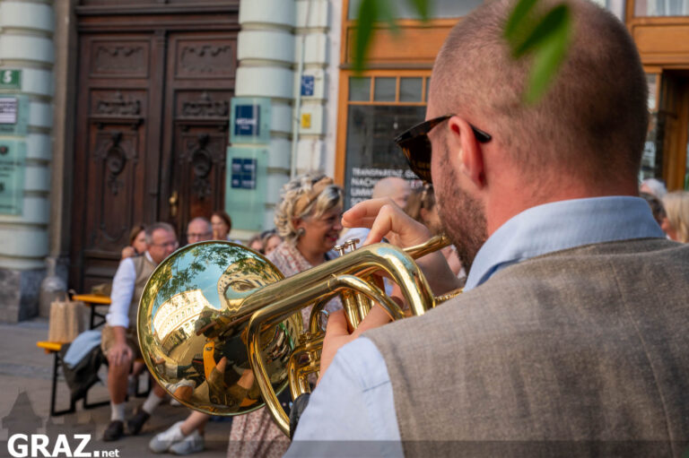 Blechbläser spielt vor einer belebten Festgasse