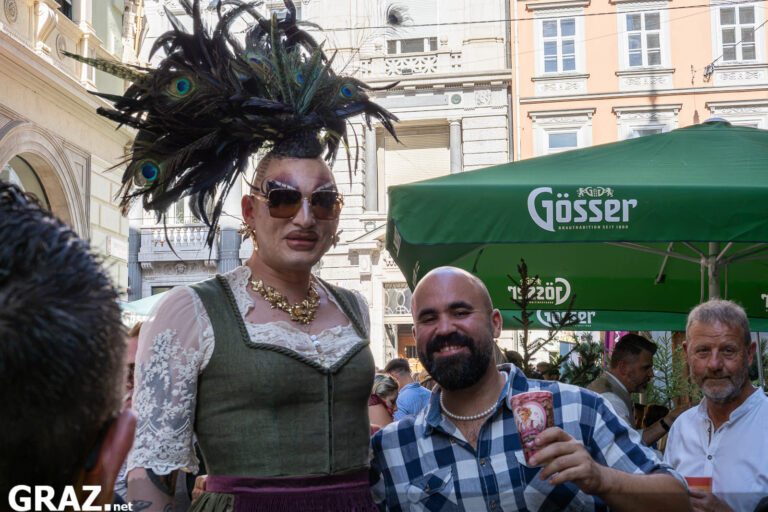 Festgast mit auffälligem Kopfschmuck nahe Jodie’s Jausn-Hüttn