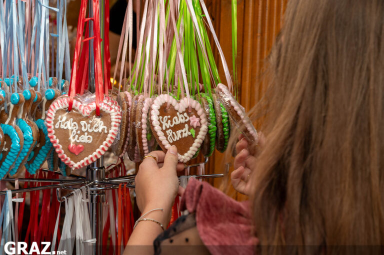 Lebkuchenherzen mit bunten Glasuren hängen an einem Stand