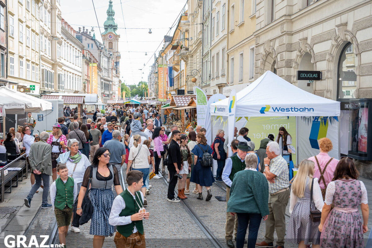Menschen flanieren zwischen Ständen in der Herrengasse
