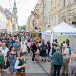 Menschen flanieren zwischen Ständen in der Herrengasse