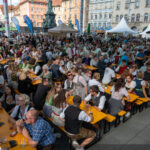 Blick über die Festtische auf eine Bühne in der Innenstadt