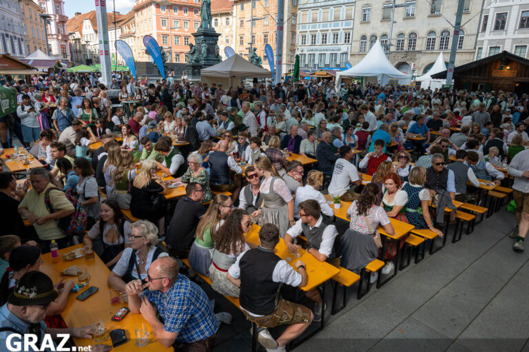 Blick über die Festtische auf eine Bühne in der Innenstadt