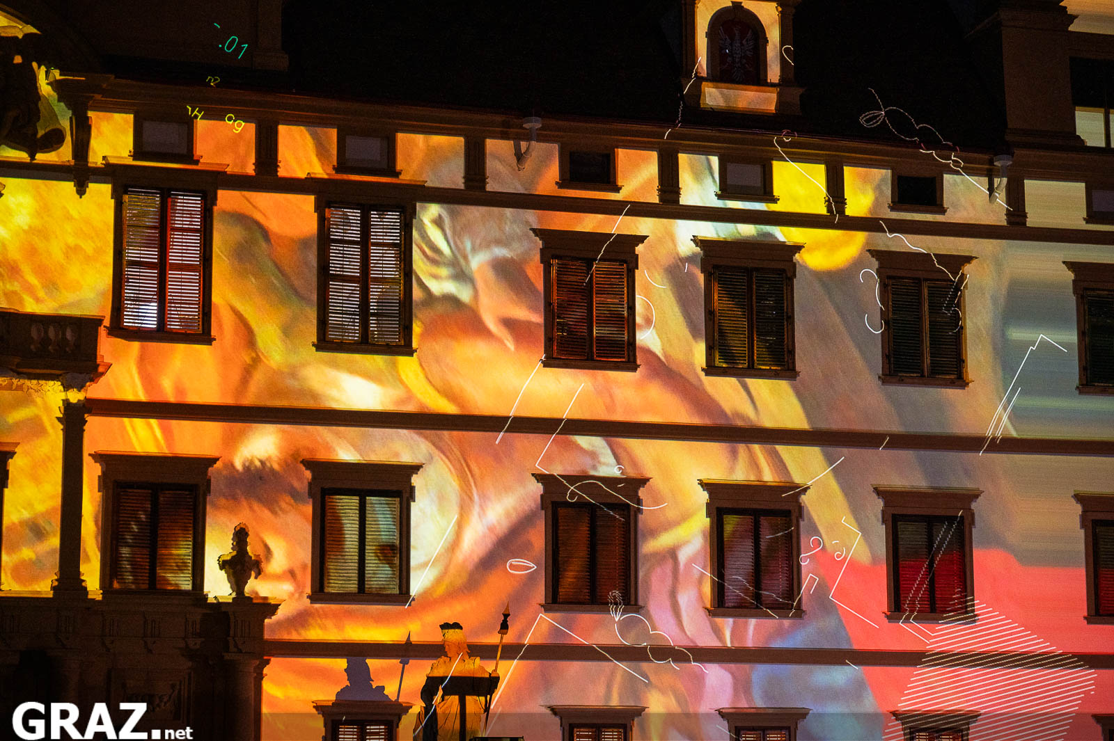 Detail der gelb und orange beleuchteten Schlossfassade während Daniel Rossas Projektion „Kadenzen“.