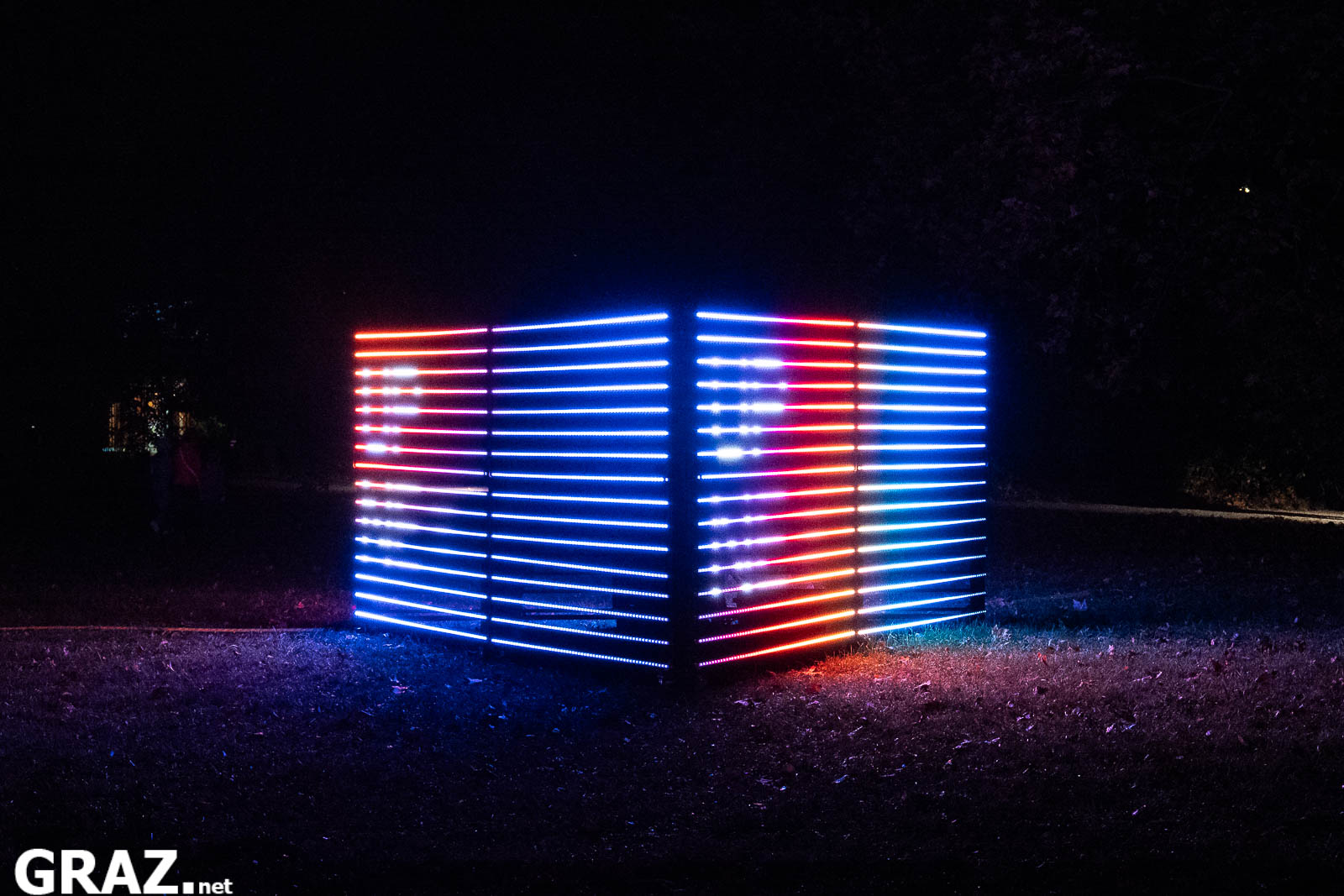 Ein Lichtkubus von „Prism“ der FH JOANNEUM und Kunstuniversität Graz leuchtet in blauen und roten LED-Streifen.