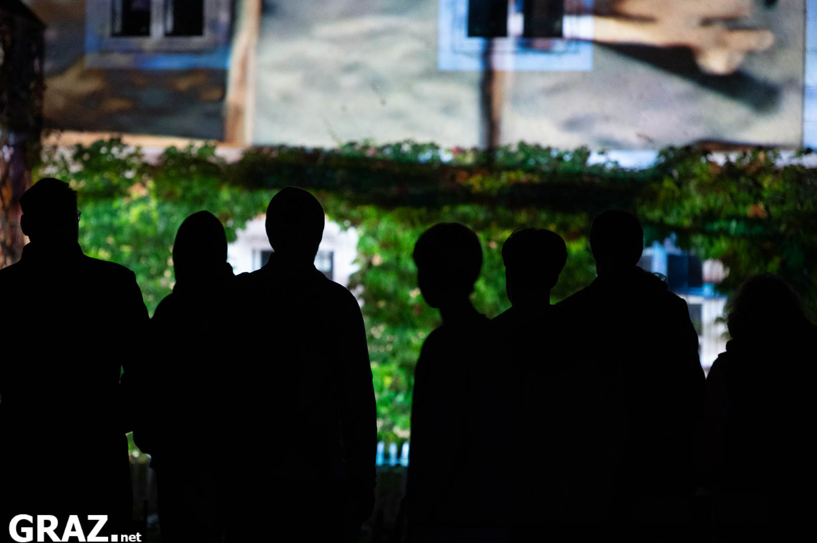 Gäste als Silhouetten vor der Videoprojektion „Energy in Time“ von Zeineb Kaabi bei Klanglicht Graz 2026.